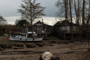 The fishing boat, Eva, lies stranded on the mud in front of the Dinner Plate Island School house at low tide.
