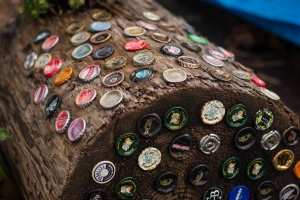Beer bottle tops in a cedar log create a novel decoration next to a gang plank leading to a resident's home.